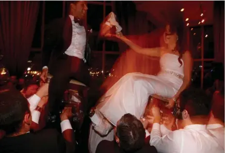  ?? ANDREW FRANCIS WALLACE PHOTOS/TORONTO STAR ?? Emma Grosberg and Ben Rogul perform the traditiona­l hora, or chair dance, a main feature at Jewish weddings.