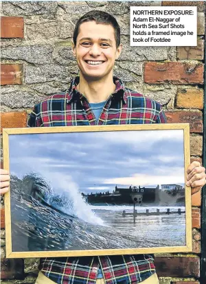  ??  ?? NORTHERN EXPOSURE: Adam El-Naggar of North Sea Surf Shots holds a framed image he took of Footdee