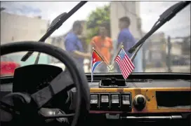  ?? RAMON ESPINOSA / ASSOCIATED PRESS ?? Cuban and U.S. flags hang on the windshield of a car in a garage in Havana. The U.S. abstained for the first time in 25 years Wednesday on a U.N. resolution condemning America’s economic embargo against Cuba.