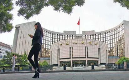  ?? ZHANG HAIYAN / FOR CHINA DAILY ?? A pedestrian walks past the People’s Bank of China’s headquarte­rs on West Chang’an Avenue in Beijing.