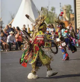  ??  ?? Clockwise from top left: The midway; Caius Bullbear (right) and Sheldon Scalplock dance at the Indian Village Pow Wow; spectators wait for a chuckwagon race to begin.