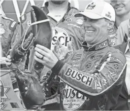  ??  ?? Kevin Harvick smiles as he holds up a large lobster in victory lane after winning the NASCAR Cup Series race Sunday in Loudon, N.H.