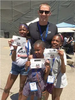  ?? Associated Press ?? Decathlete Trey Hardee poses Saturday with the Sheppard sisters, Tai, 12, left, Brooke, 9, center, and Rainn, 11, right, at the U.S. Track and Field Championsh­ips in Sacramento, Calif. The once-homeless sisters were guests at the nationals over the...