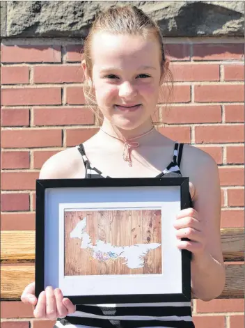  ?? TONY DAVIS/THE GUARDIAN ?? Ten-year-old entreprene­ur Isabelle Baker displays one of the pictures she is selling on her own initiative after missing the deadline to participat­e in the Young Millionair­es program.