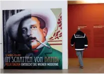  ??  ?? A man passes by a poster of Felix Salten (left) as he enters the exhibition ‘Beyond Bambi - Felix Salten and the Discovery of Viennese Modernism’.