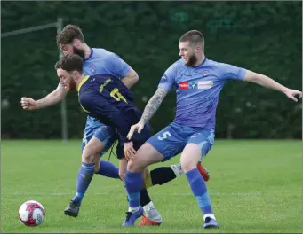  ??  ?? Danny Furlong of Rosslare Rangers is challenged by Paul ‘Patsy’ Malone and Gary Delaney.