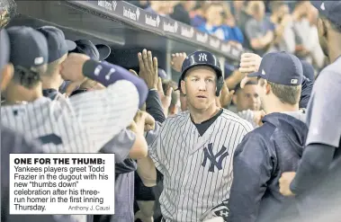  ?? Anthony J. Causi ?? ONE FOR THE THUMB: Yankees players greet Todd Frazier in the dugout with his new “thumbs down” celebratio­n after his threerun homer in the first inning Thursday.