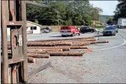  ??  ?? BELOW: A pulpwood truck driver lost his load of logs while making a left turn off U.S. 411 onto Ga. 100 in Cave Spring Monday morning. The logs spilled primarily into the parking lot of La Cabana restaurant.