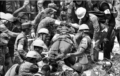  ?? PEDRO PARDO / AGENCE FRANCE-PRESSE ?? A survivor is rescued from the rubble of a flattened building in Mexico City on Wednesday as the search mission continues a day after a magnitude-7.1 earthquake hit central Mexico.