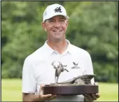  ?? Associated Press ?? ALL SMILES Lucas Glover holds the trophy after winning the John Deere Classic on Sunday at TPC Deere Run in Silvis, Ill. It was his first win in 10 years.