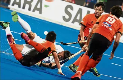  ??  ?? Great effort: Malaysia’s Faiz Jali (left) going for a sliding tackle against Pakistan’s Muhammad Atiq during the Hockey World Cup Group D match at the Kalinga Hockey Stadium in Bhubaneswa­r yesterday. The match ended in a 1-1 draw.