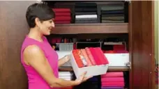  ?? JONATHAN NICHOLLS FOR THE TORONTO STAR ?? Profession­al organizer Clare Kumar shows how using small boxes and colour-coding clothing can keep a closet organized and intact.