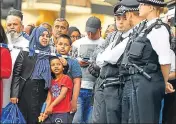  ?? AFP ?? A boy watches police officers standing guard in London.