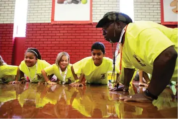  ?? Photo by Hunt Mercier ?? ■ Officer Alvin Howard does pushups with team yellow Monday during P.R.I.D.E. Academy at College Hill Middle School in Texarkana, Ark. The academy is a five-day camp for sixth-graders that provides the tools for students to make smart life choices.