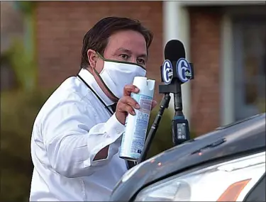  ?? PETE BANNAN - MEDIANEWS GROUP ?? Area journalist­s are doing the right things to keep save. 6ABC’s Dann Cuellar disinfects his microphone after a recent interview.