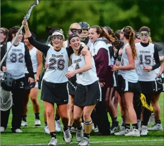  ?? SARAH GORDON/THE DAY ?? East Lyme’s Elena Hynes (26) and Hailey Gordon (4) celebrate after the top-seeded Vikings won their 11th straight ECC girls’ lacrosse tournament championsh­ip with a 16-5 win over No. 2 Stonington on Thursday.