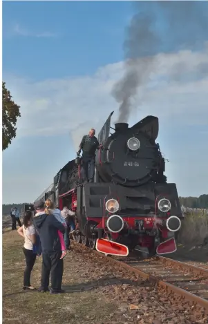  ??  ?? A local family admire No. Ol49‑69 at Stefanowo on October 4, as Andrzej Macur ‑ the Wolsztyn driver who’ll sell you anything from a PKP cap to a replica cabside numberplat­e ‑ climbs along the running plate to oil the air pump. TOBY JENNINGS