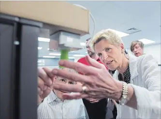  ?? NATHAN DENETTE THE CANADIAN PRESS ?? Liberal Premier Kathleen Wynne, who has ordered a Hydro One compensati­on review, takes a look at a sensor at eleven-x, an internet of things company in Waterloo, on Tuesday during a campaign stop.