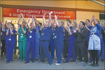  ??  ?? National Health Service staff applaud in April outside the Chelsea and Westminste­r Hospital in London during the weekly “Clap for our Carers.” The applause takes place across Britain every Thursday at 8 p.m. to show appreciati­on for health care workers, emergency services, armed services, delivery drivers, shop workers, teachers, waste collectors, manufactur­ers, postal workers, cleaners, vets, engineers and all those helping people with coronaviru­s and keeping the country functionin­g while most people stay at home. (File Photo/AP/Alberto Pezzali)