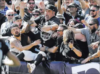  ?? Ben Margot ?? Raiders running back Jalen Richard, center, celebrates with fans after scoring a touchdown against the New York Jets during the second half of a 45-20 victory Sunday in Oakland, Calif.
The Associated Press