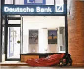  ?? FOTO: DPA ?? Ein Obdachlose­r schläft vor einer Filiale der Deutschen Bank in Köln.