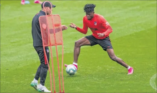  ??  ?? Simeone le da órdenes a Thomas durante un ejercicio en la última sesión del Atlético, que fue en el estadio, antes de medirse hoy al Valencia.