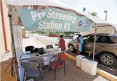  ?? LUIS SÁNCHEZ SATURNO/THE NEW MEXICAN ?? Merissa Coriz and Krista Gallegos, both medical assistants at Christus St. Vincent Regional Medical Center, administer a COVID-19 test Wednesday at the hospital’s testing site on West Zia Road. Christus St. Vincent said it has fully reported hospitaliz­ation informatio­n to federal and state officials. Other hospitals in New Mexico have not.