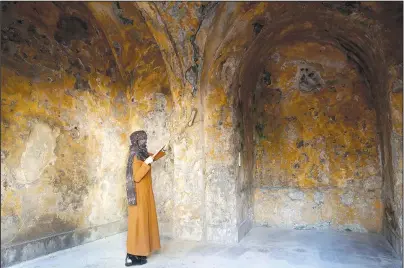  ?? The Associated Press ?? ABANDONED: A female artist volunteer cleans a room of the long-abandoned 200-year-old al-Kamalaia school on Sunday in the old quarter of Gaza City. Less than 200 of these old houses are still partly or entirely standing, according to officials and they are threatened by neglect, decaying and urban sprawl.