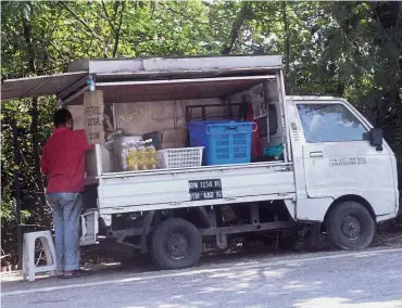  ??  ?? Off the lorry: An operator selling petrol by the roadside in Jalan Teluk Kumbar, Penang.