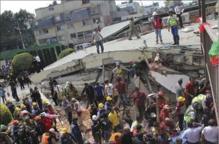  ?? CARLOS CISNEROS — THE ASSOCIATED PRESS ?? Rescue workers search for children trapped inside the collapsed Enrique Rebsamen school in Mexico City, Tuesday. The earthquake stunned central Mexico, killing more than 100 people as buildings collapsed in plumes of dust.