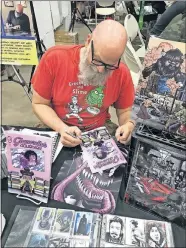  ?? [MATTHEW PRICE] ?? Artist Jerry Bennett signs a copy of “Glamorella's Daughter” at New World Comic Con.