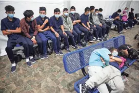  ?? DARIO LOPEZ-MILLS, POOL/AP ?? Young unaccompan­ied migrants wait for their turns at the secondary processing station at the U.S. Customs and Border Protection facility in Donna, Texas, on March 30.