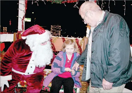  ?? FILE PHOTO ?? Santa will be visiting Lincoln again on Dec. 13 at the Christmas On the Square, beginning at 5 p.m. on the downtown square. Santa will again be at the gazebo to meet children as he did the child above to hear their Christmas lists.