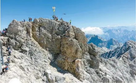  ?? RICK STEVES ?? A golden cross marks the top of the Zugspitze – the highest point in Germany. The mountain straddles the border between Germany and Austria.