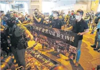  ??  ?? Pro-democracy lawmakers Lam, with black mask, left, and Andrew Wan Siu-kin, right, are accompanie­d by two people who were injured in the Yuen Long subway attack on July 21.