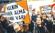  ??  ?? ISTANBUL: Protesters hold signs reading ‘People have right to have news’ during a protest in front of opposition Cumhuriyet newspaper in Istanbul yesterday after a police operation at the daily’s headquarte­rs. — AFP