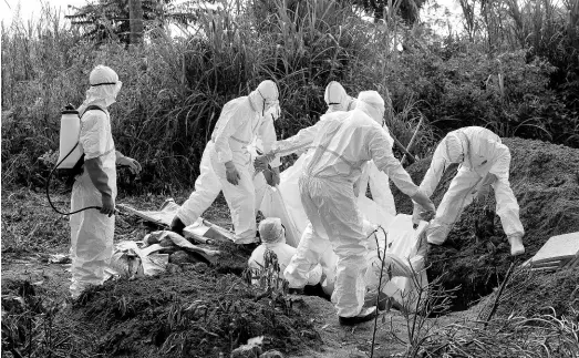  ??  ?? In this Sunday, July 14 photo, workers bury the remains of Mussa Kathembo, an Islamic scholar who had prayed over those who were sick in Beni, Congo. Kathembo died of Ebola.