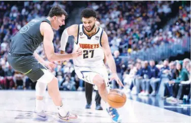  ?? Associated Press ?? ↑
Denver Nuggets’ Jamal Murray (right) drives past Minnesota Timberwolv­es’ Luka Garza during their NBA game in Denver.