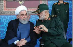  ?? AP/Iranian President’s Office ?? Iranian President Hassan Rouhani (left) listens to Gen. Hossein Salami, chief of the Revolution­ary Guard, at a military parade Sunday outside Tehran.