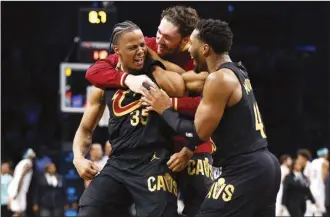  ?? AP photo ?? Cavaliers forward Isaac Okoro celebrates with teammates Cedi Osman and Donovan Mitchell after making the game-winning shot Thursday.