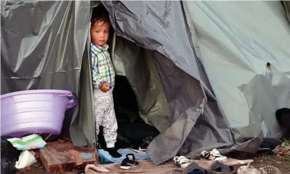  ?? Photograph: Elvis Barukcic/AFP/Getty ?? A boy stands at the entrance of a tent at an improvised camp near the Bosnia-Croatia border.