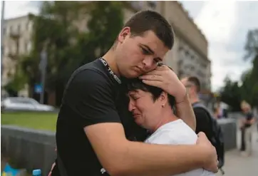  ?? JAE C. HONG/AP ?? War in Ukraine: Iryna Pelekhata is comforted by her younger son, Maxym Pelekhatyi, as they gather Saturday in Independen­ce Square in Kyiv to mark the one-year anniversar­y of the deadly attack on the Olenivka prison in the Russian-held part of eastern Ukraine in which dozens of prisoners of war were killed. Pelekhata’s husband and other son were killed in the war. Ukraine President Volodymyr Zelenskyy described the prison attack as one of Russia’s “most vile and cruel crimes.”