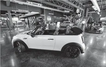  ?? David Zalubowski/associated Press ?? A Cooper SE electric vehicle on the showroom floor of a Mini dealership. A new bill supporting families and infrastruc­ture would also grant tax credits to some buyers of new and used EVS.