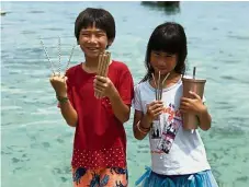  ??  ?? Eco-friendly options:
Children at Bubbles Dive Resort in Pulau Perhentian holding up paper straws and reusable metal and bamboo straws.