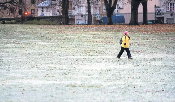  ??  ?? A woman crossing a frost-covered Baxter Park in Dundee during a prolonged cold spell of weather earlier this month.