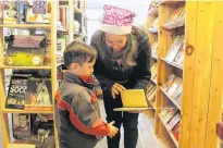  ?? COLIN MACLEAN/JOURNAL PIONEER ?? Nancy Quinn, owner of Seaside Books on Water Street in Summerside, talks books with young customer Hendrix Dunham.