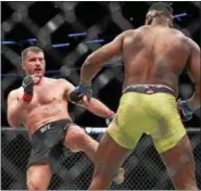  ?? TIM PHILLIS - THE NEWS-HERALD ?? Stipe Miocic kicks Francis Ngannou during their UFC heavyweigh­t championsh­ip bout Jan. 20 in Boston.