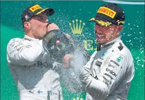  ?? RYAN REMIORZ / THE CANADIAN PRESS VIA AP ?? Canadian Grand Prix winner Lewis Hamilton (right) celebrates with fellow Team Mercedes driver and second-place finisher Valtteri Bottas in Montreal on Sunday.