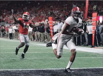  ?? CURTIS COMPTON THE ASSOCIATED PRESS ?? Alabama’s Devonta Smith runs into the end zone for a touchdown after catching a pass ahead of Georgia’s Malkom Parrish during the NCAA college football playoff championsh­ip game in Atlanta last January.