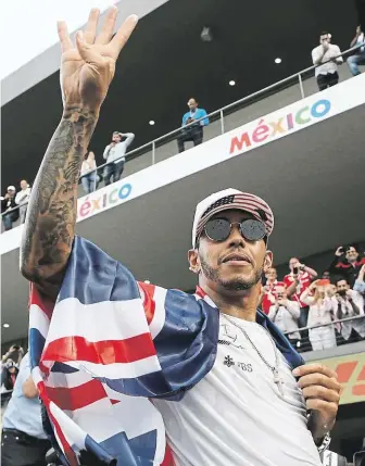  ?? Lewis Hamilton prsty signalizuj­e počet získaných titulů ve formuli 1. FOTO ČTK/ AP ?? Mistrovské oslavy.